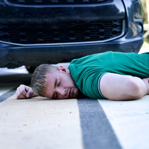 A pedestrian lies injured in front of a car, depicting a Los Angeles pedestrian injury.