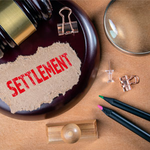 Paper with settlement text on a gavel, for personal injury claims in California.